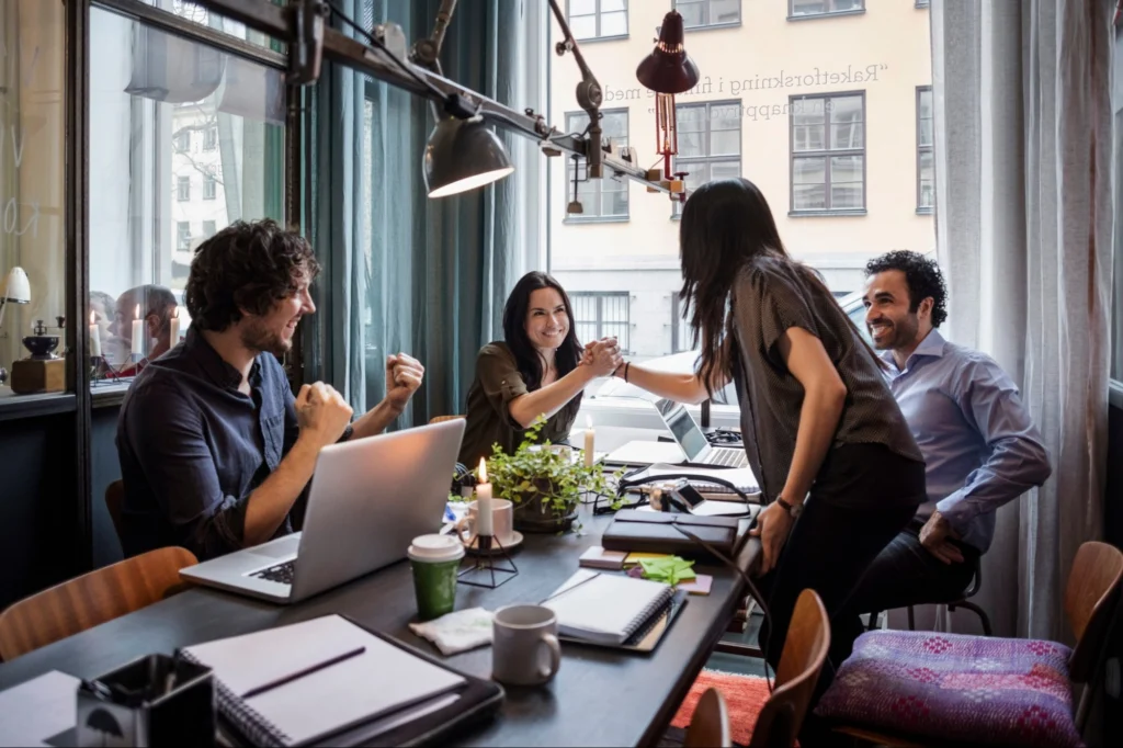 Professional services team celebrating together around an office table
